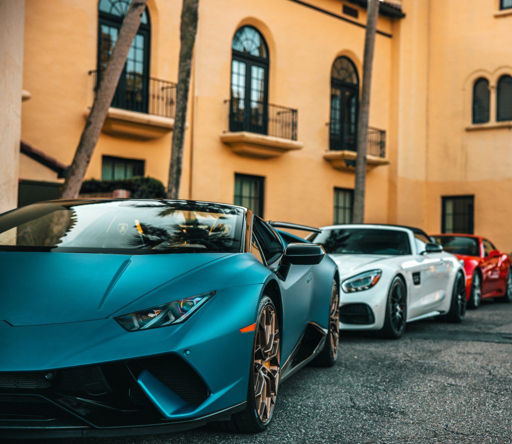 A row of supercars parked in front of a building.